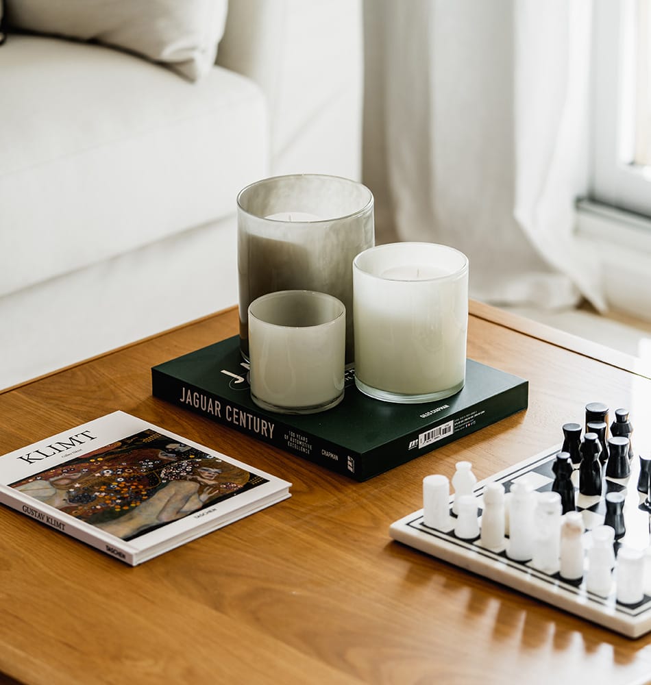 A close-up of a coffee table adorned with candles and a chessboard, showcasing the stylish interior of one of Flipzor's renovated apartments in Spain.